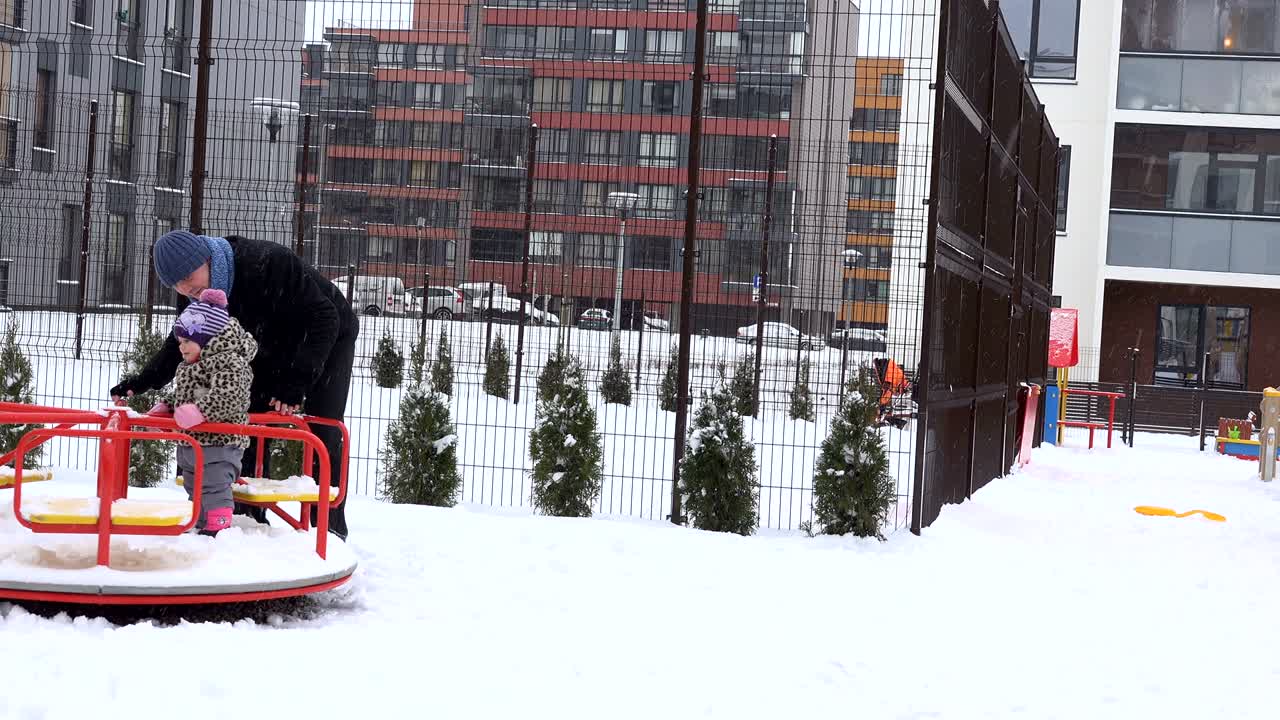 padre y la niña girar en el columpio del círculo en el patio de juegos en el jardín de invierno. 4k