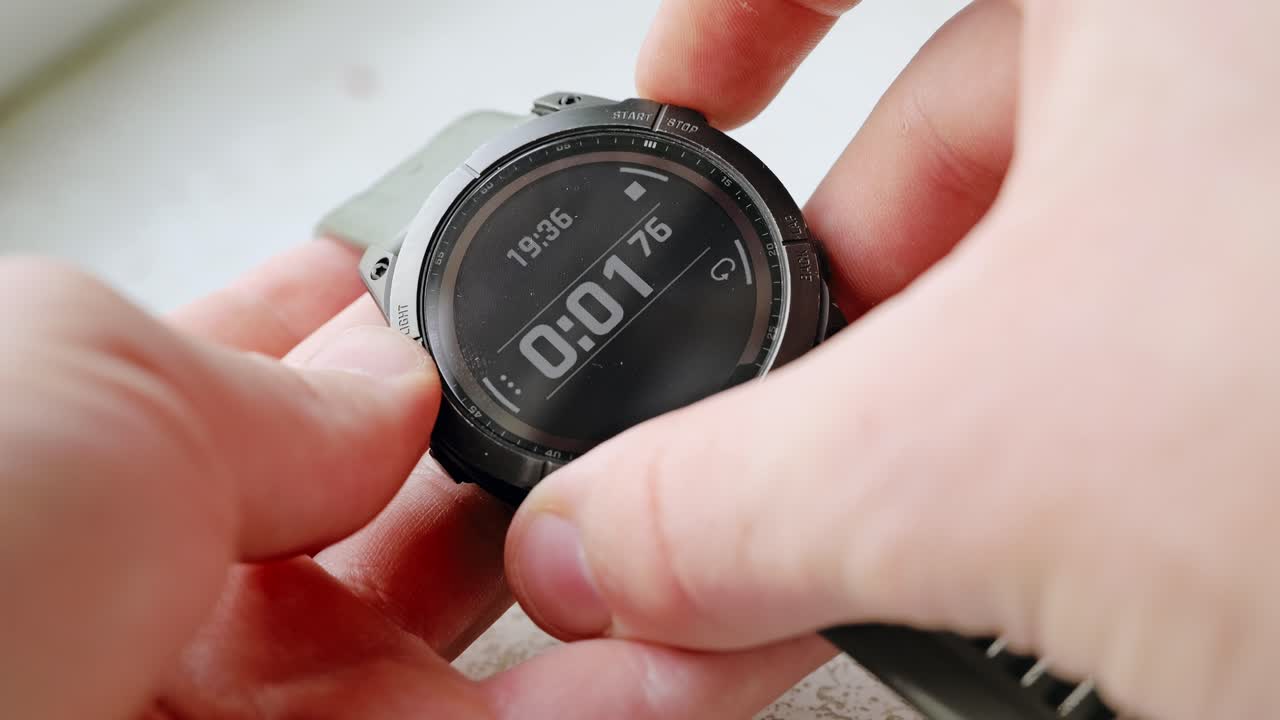 Slow motion closeup man pressing start on black digital watch with timer display