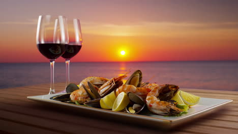 seafood dinner with red wine at sunset by the ocean
