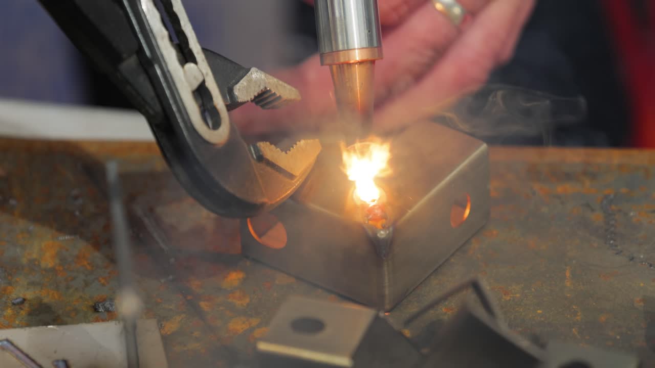 Macchina per saldatura laser con saldatore a pistola. La saldatura laser è mostrata in primo piano