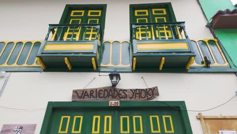 puerta verde brillante con acento amarillo con vista hacia arriba hacia el balcón