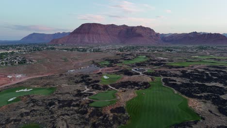 aerial view of a desert golf course with large red mountains