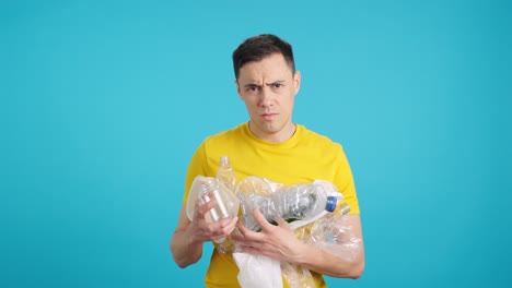 man holding plastic bottles for recycling