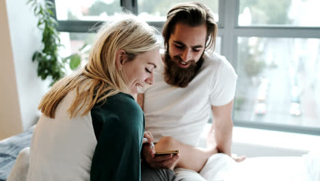 couple using mobile phone on bed at home 4k