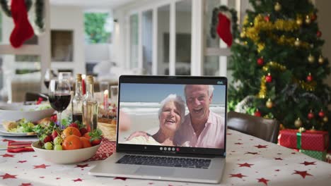 Feliz-Pareja-De-Ancianos-Caucásicos-En-El-Portátil-Tumbado-En-La-Mesa-De-Navidad