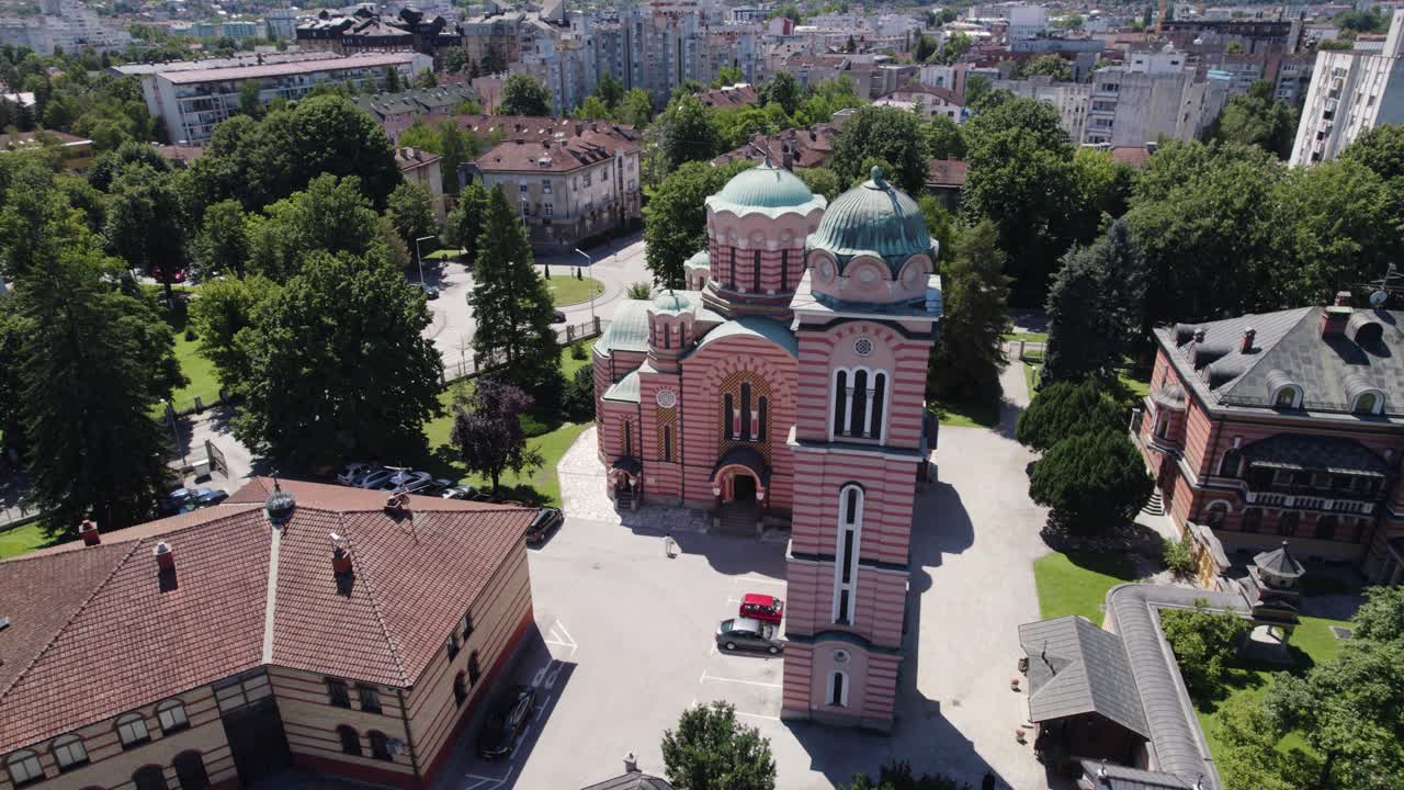 desde el aire: la iglesia de la santa trinidad en banja luka rodeada de frondosos árboles, bosnia