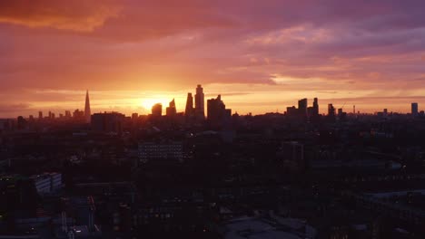 cinematic aerial shot of the beautiful sunset between skyscrapers of london skyline