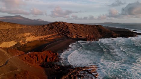 golden hour aerial drone footage of el golfo’s green lake (charco de los clicos) and black sand beach in yaiza, lanzarote, canary islands, spain.