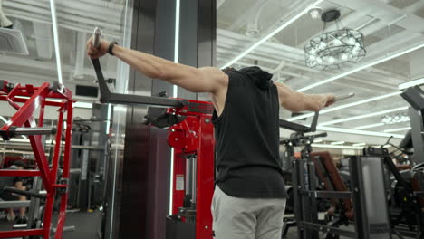 hombre haciendo hombro lado levanta entrenamiento delts en el gimnasio - ángulo bajo