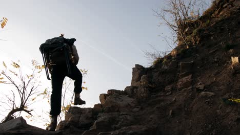 hiker climbing rock trail with backpack in high mountain, vogelberg, lepontine alps