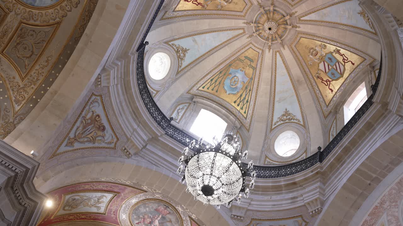 bright church ceiling with painted dome and hanging crystal chandelier