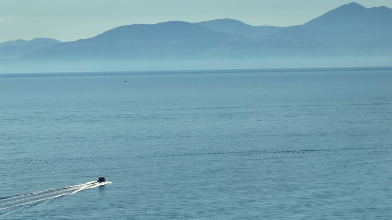 뉴질랜드의 은 날 태즈만 만의 반이는 물을 가로질러 날아다니는 파워 보트의 드론