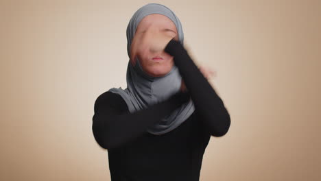 Upset-woman-in-hijab-showing-thumbs-down-sign-gesture,-disapproval,-dissatisfied-dislike