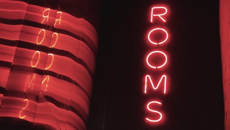 Red-Neon-signs-spelling-"rooms"-and-an-abstract-reflection-of-the-words