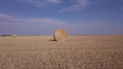 low arching orgit of big round hay bales