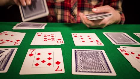 close up of female hands holding cards and playing solitaire