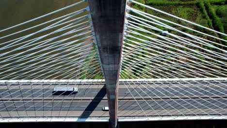 Drohne-Mit-Blick-Auf-Ein-Einmastiges-Aufhängungskabelsystem-Mit-Verkehrsüberquerung-An-Der-Brücke,-Beeindruckende-Struktur-Und-Transportsystem-In-Betrieb