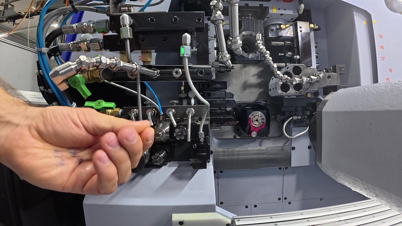 A worker operates an industrial machine without wearing protective gloves, demonstrating unsafe work practices and the importance of personal protective equipment in manufacturing environments.