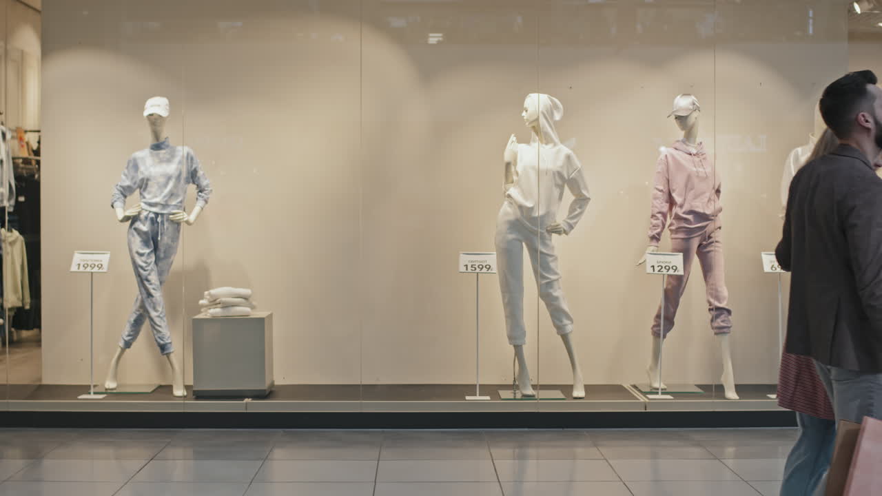 Couple Looking At Window Display While Shopping For Clothes