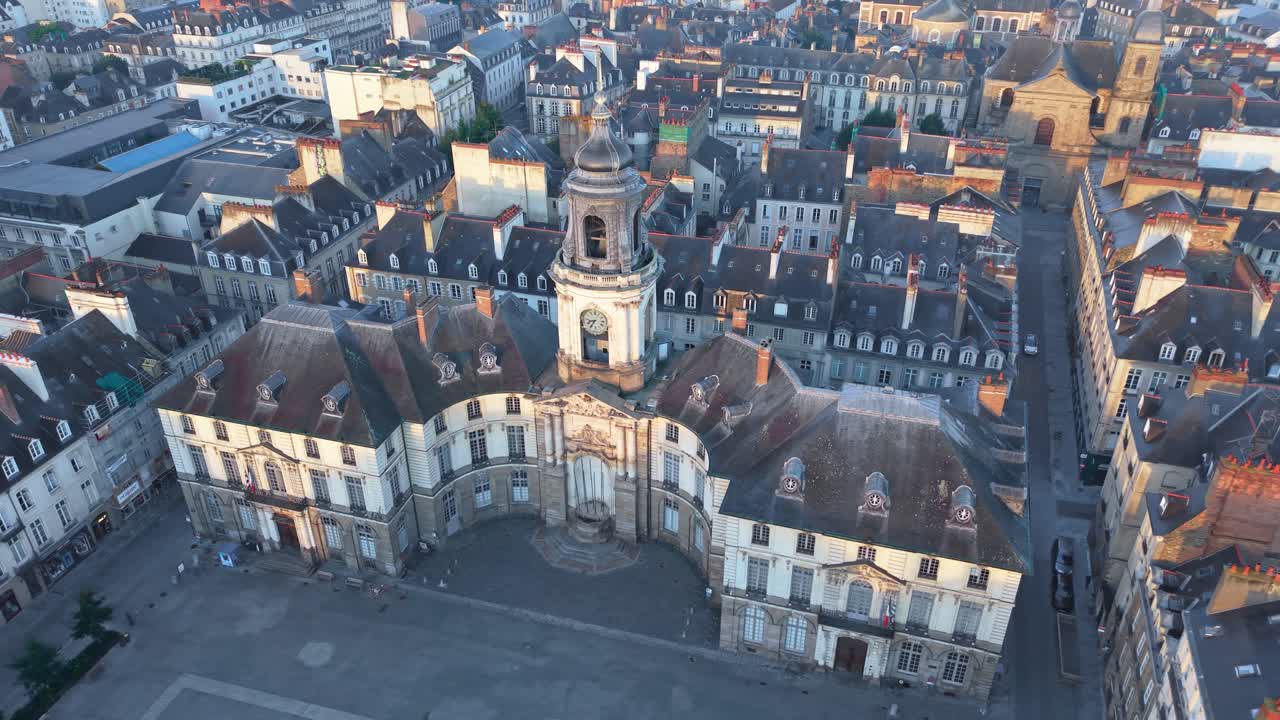 Ripresa aerea orbitale destra del municipio di Rennes in Place de la Mairie con Palais du Commerce sullo sfondo, soffice luce mattutina