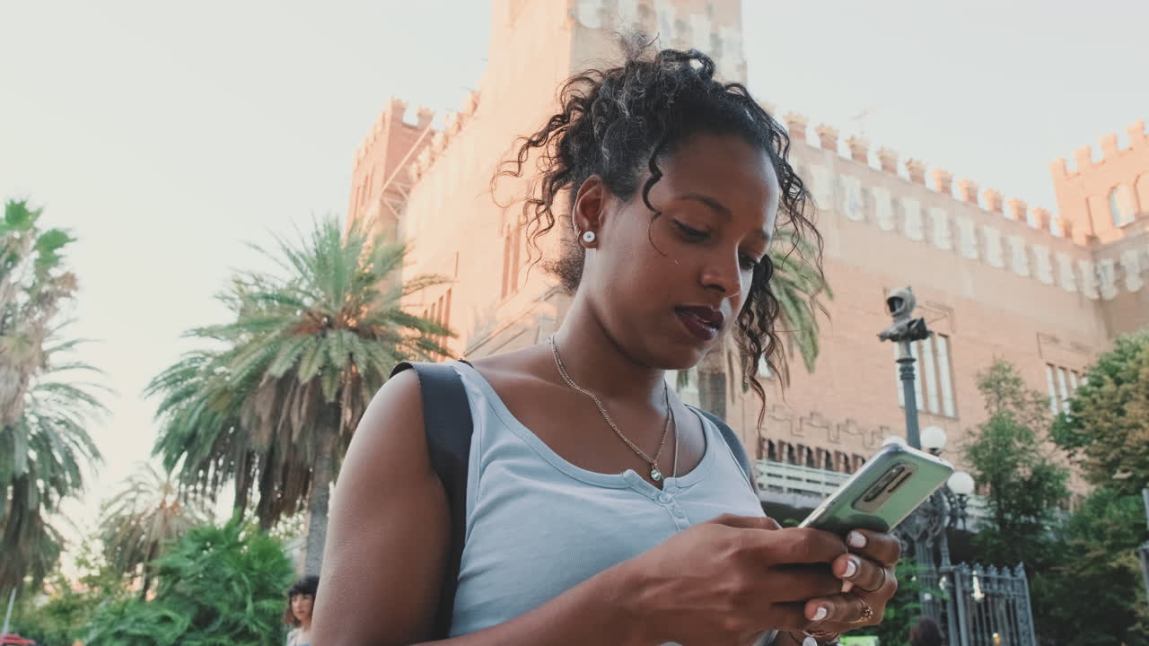 Vrouw gebruikt mobiele telefoon voor een gebouw