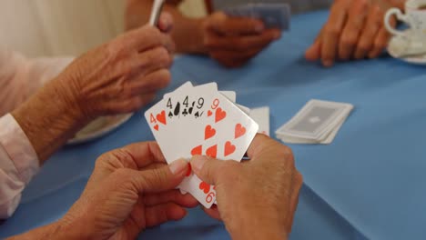 amigos mayores jugando a las cartas