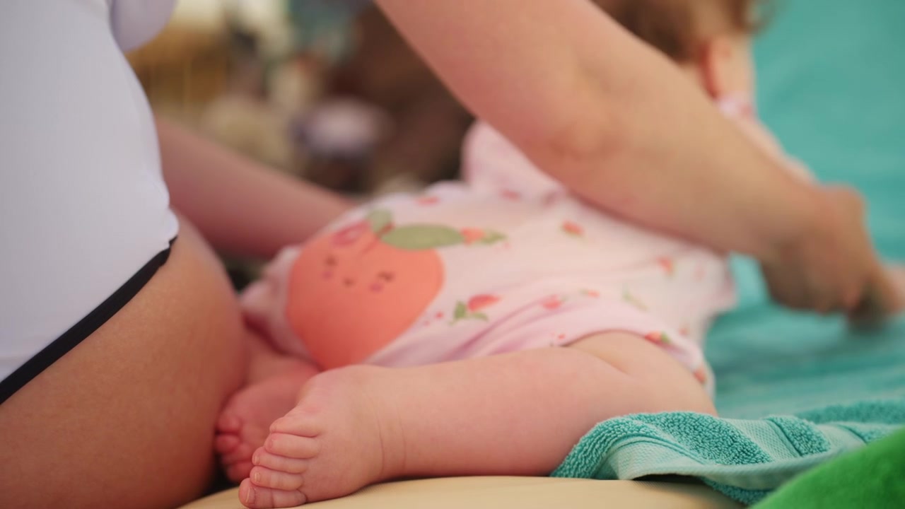 Riprese cinematografiche ravvicinate di un bambino che riposa accanto a un genitore su un lettino da spiaggia durante le vacanze estive
