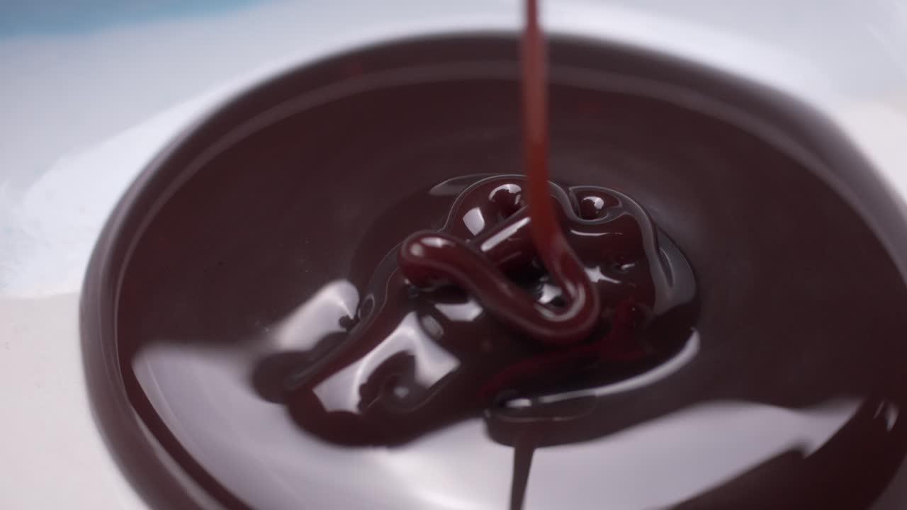 Pouring a creamy chocolate syrup. Macro close up