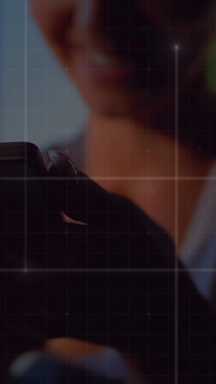 Video verticale: Una donna che muove il telefono, inquadrando un selfie allo specchio, in jeans e canotta, con una griglia sovrapposta che guida la composizione per i social.