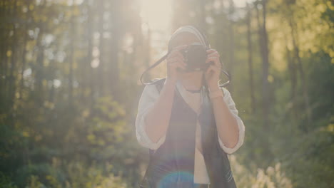 smiling tourist photographing through camera in forest