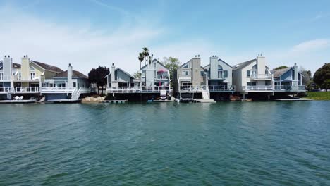 low slider shot from clear blue lagoon water showing remarkable design of villas, san mateo