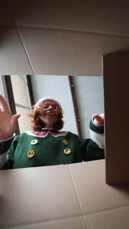 mujer emocionada abriendo una caja de regalos de navidad