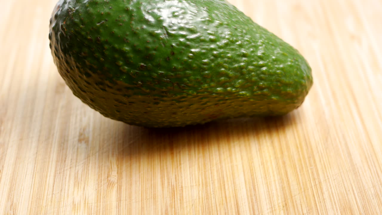 Avocado intero su un tagliere di legno