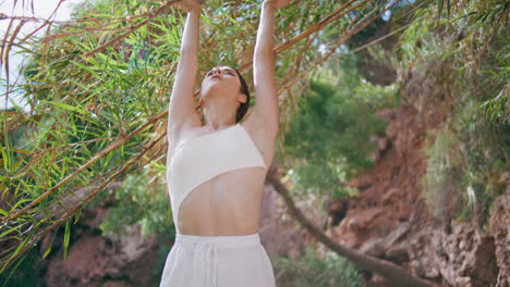 meditative lady breathing exercises on exotic jungle nature. woman stretching