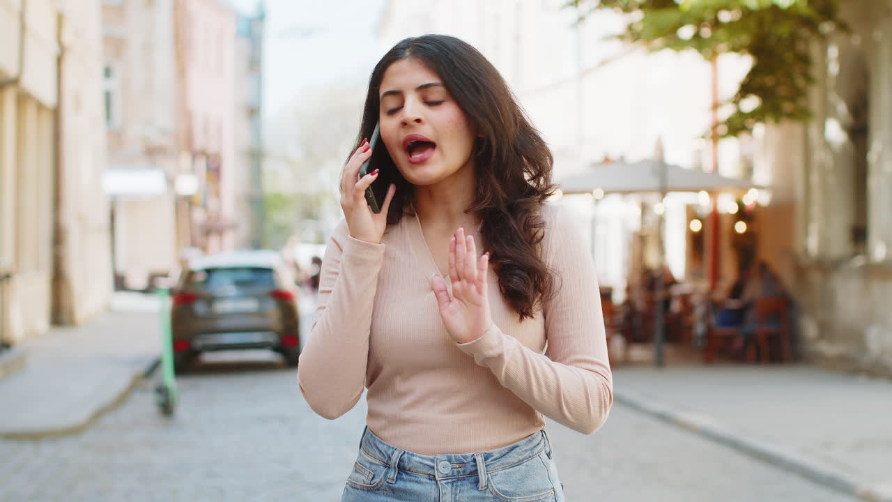 Donna indiana o araba arrabbiata e stressata che discute animatamente al telefono, urlando e litigando.