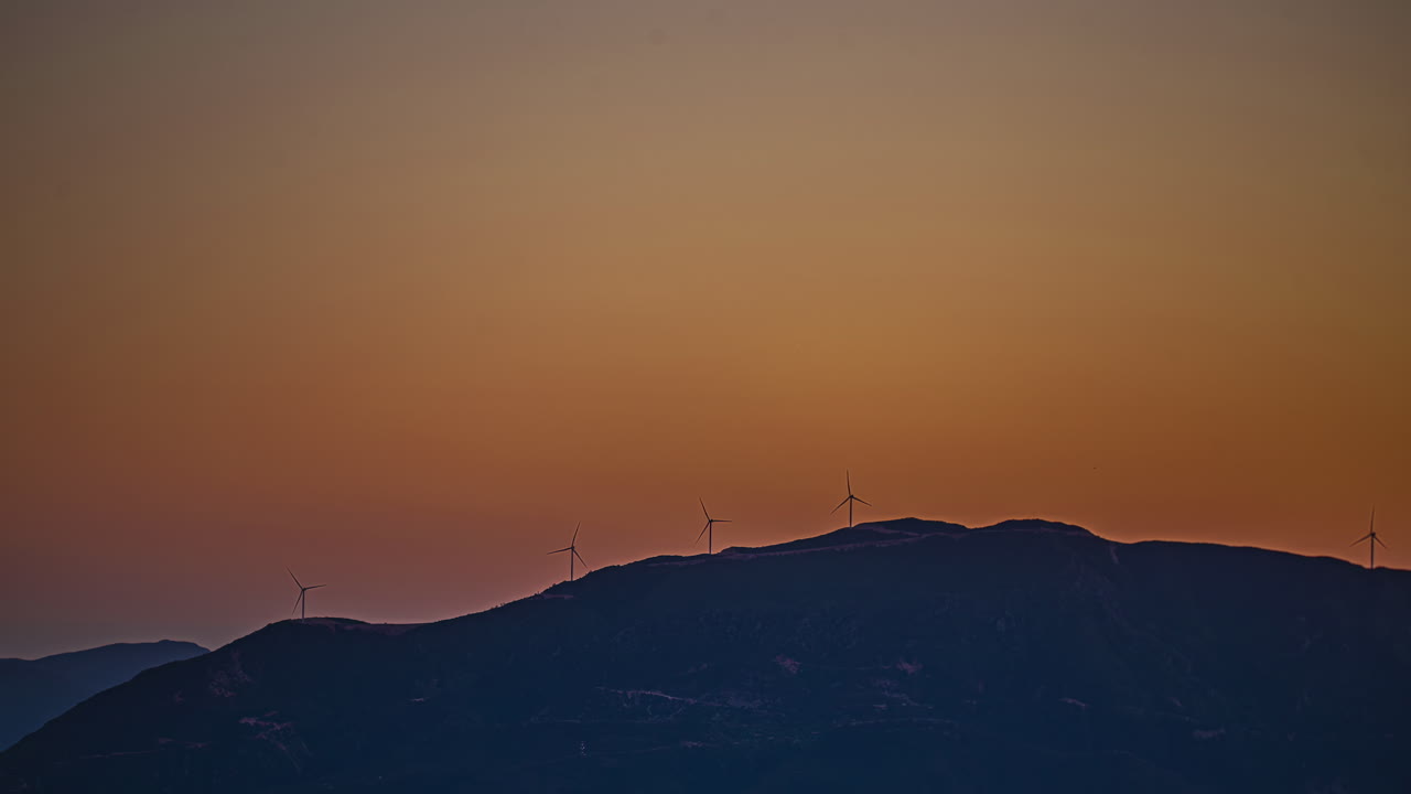 산 꼭대기에 에너지를 생산하는 풍력 터빈의 실루, 거리 시간 지연 시각
