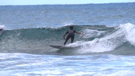 surfista monta una ola en cámara lenta en la playa de gran canaria