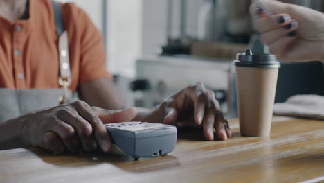 barista processing payment at cafe