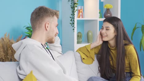 una joven pareja feliz charlando en casa, aliviando el anhelo, pasando un buen rato.