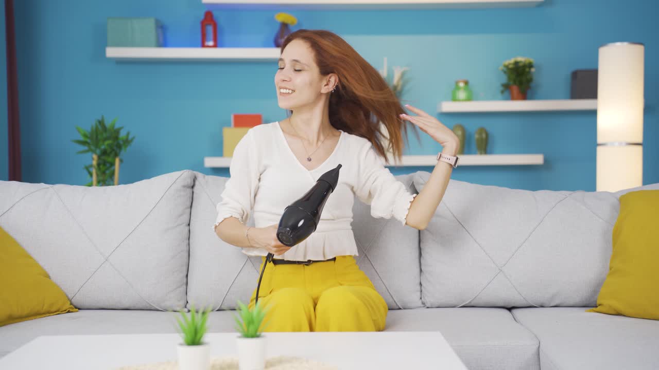 젊은 여성이  ⁇  건조기와 함께 노래하고 춤을 추고 있습니다.