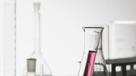 video of glass laboratory test tube with pink liquid in beaker with copy space on white background