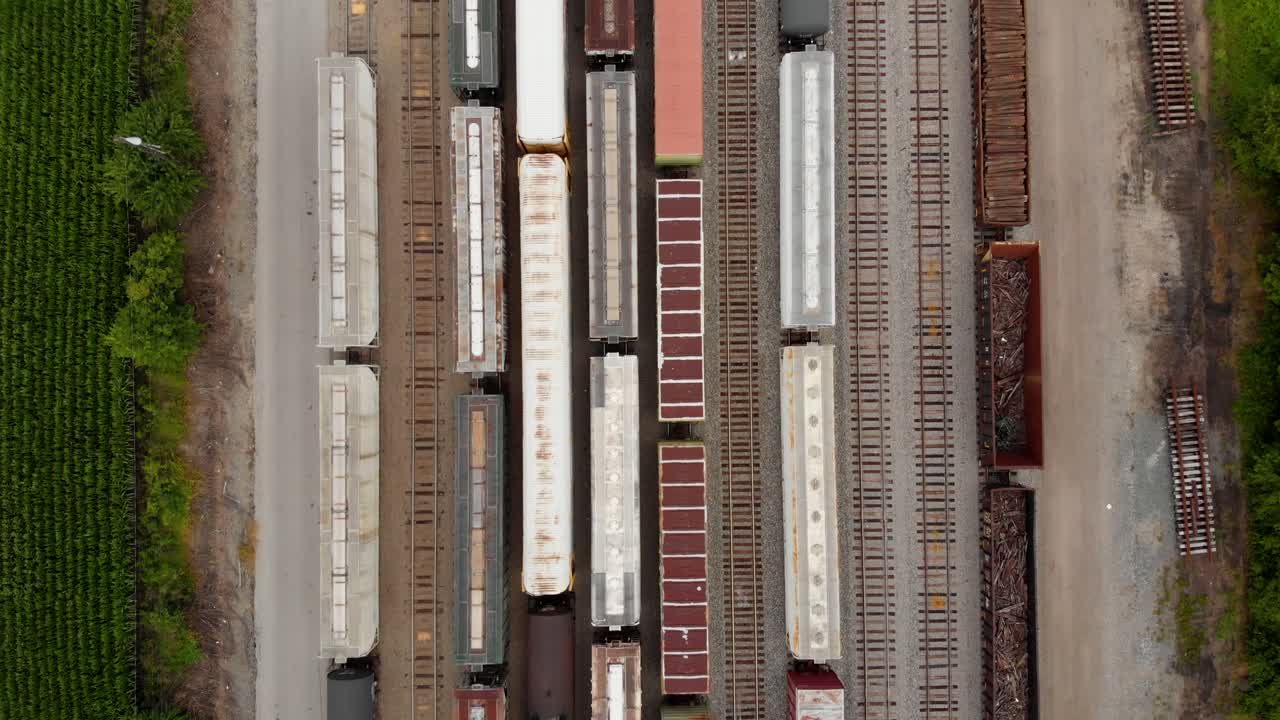 4k top down view moving from top to bottom showing multiple trains while parked at a train station
