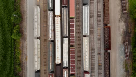 vista de arriba hacia abajo de 4k que se mueve de arriba a abajo mostrando varios trenes mientras está estacionado en una estación de tren