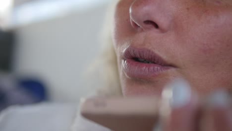 close-up of a woman's lips as she speaks into her smartphone