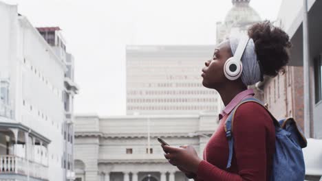 afroamericana usando su teléfono inteligente en la calle
