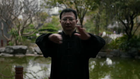 man practicing martial arts in a traditional chinese garden