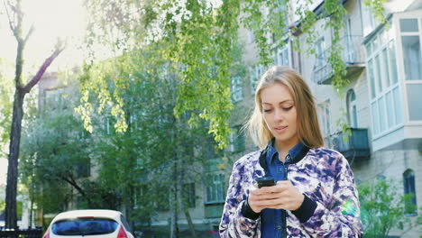 Attractive-Woman-Walking-In-The-City-Enjoys-A-Smartphone-Prores-422-10-Bit