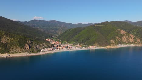 bright sunny day, aerial view of a coastal town in italy with mountains in the background