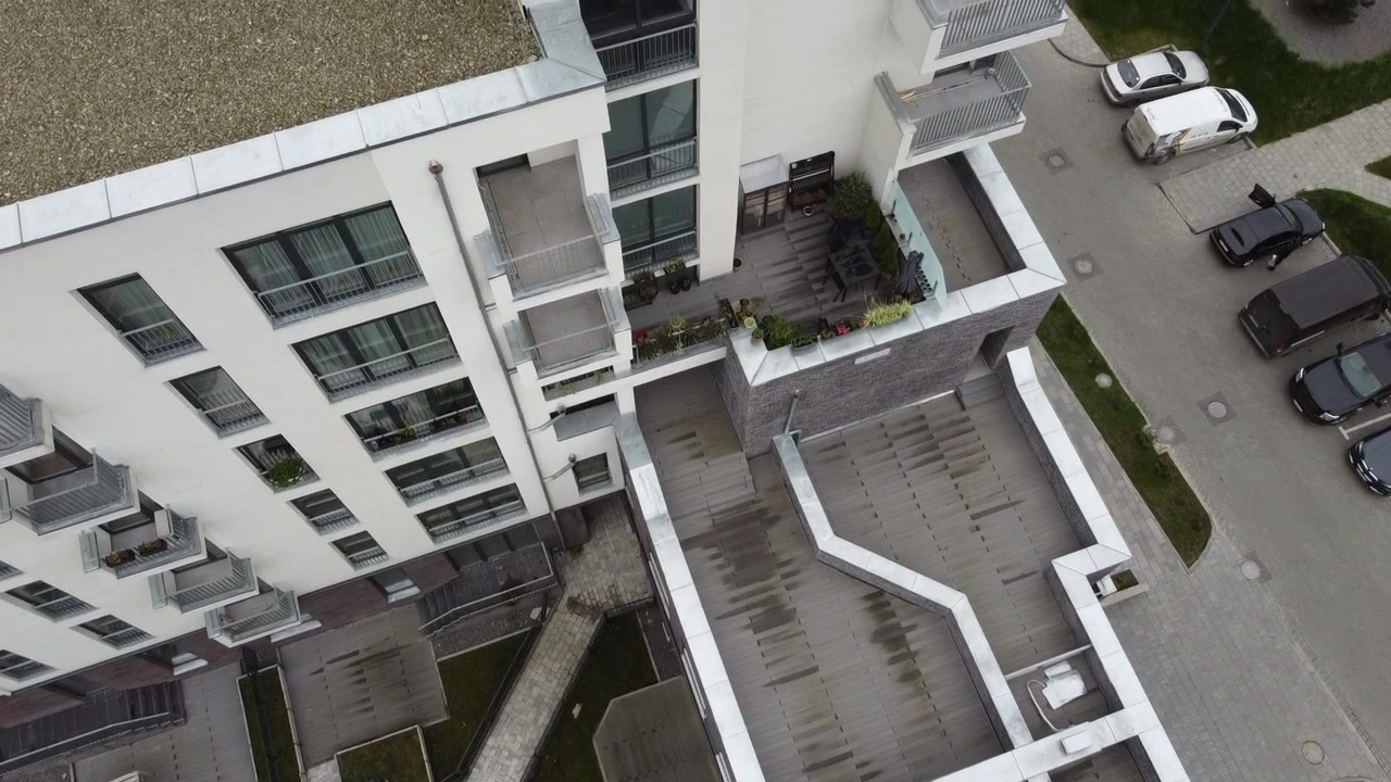 Vista aerea di un drone in volo sopra edifici residenziali, riprese di tetti e architettura.
