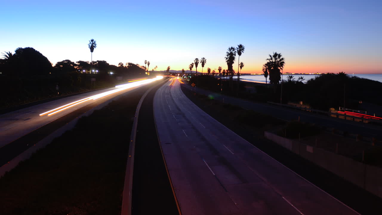los coches de lapso de tiempo viajan por una autopista al atardecer o al anochecer 6